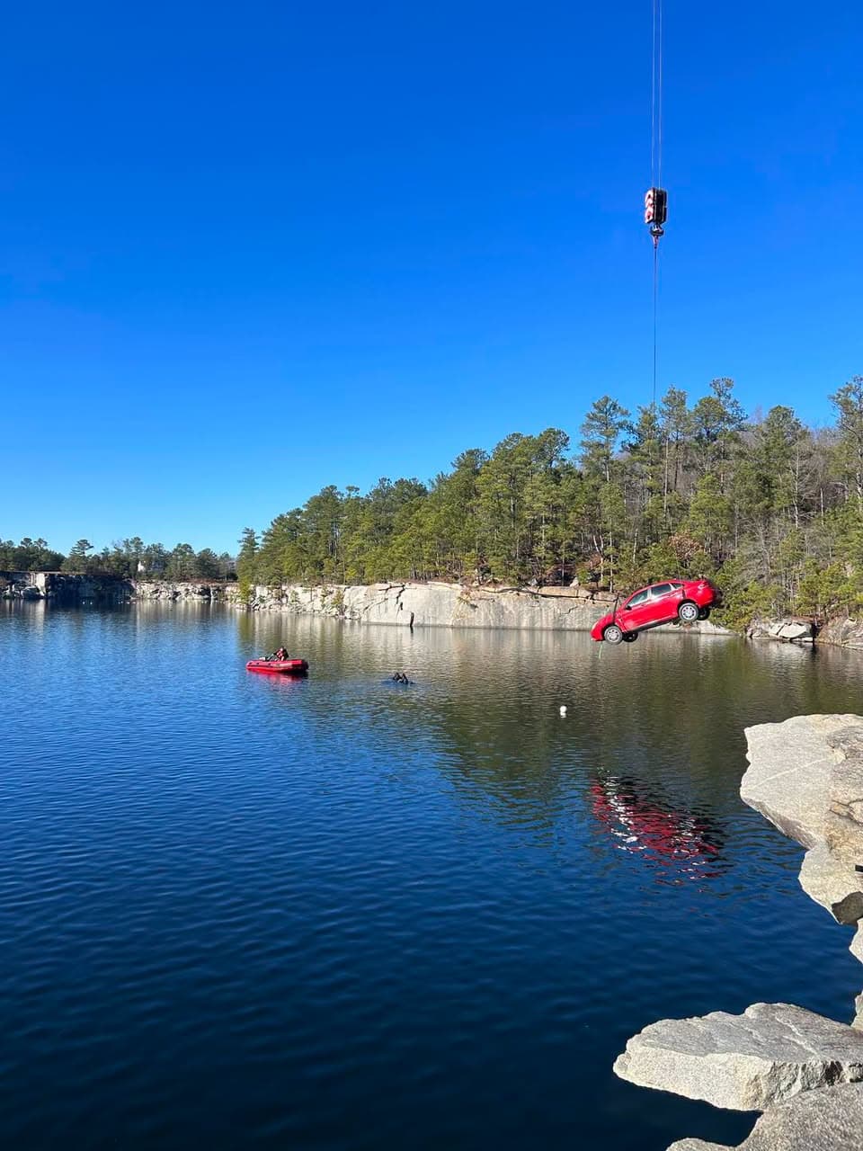 A vehicle being lowered into a quarry for dive-team training
